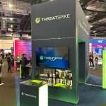 Wood-effect vinyl-wrapped T3 door providing concealed storage space within the modular sustainable exhibition stand.