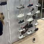 Duca del Cosma golf shoes displayed on white T3 acrylic shelves at PGA Show Orlando