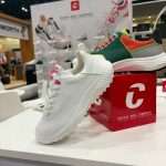 Close-up of Duca del Cosma footwear on acrylic display shelf within modular exhibition stand