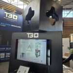 Black T3 Deco exhibition system with integrated lighting and sculptural design details at C!Print Lyon