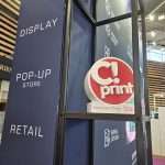 Close-up of branded exhibition graphics and C!Print Lyon signage on custom-built stand